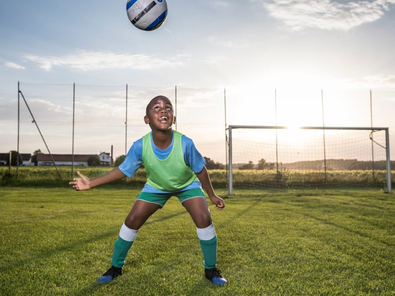 young-football-player-heading-the-ball-on-football